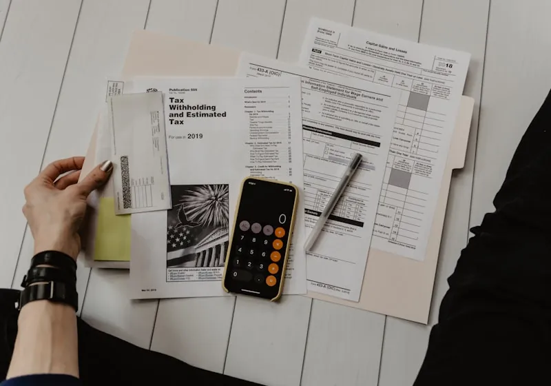Financial documents and a calculator on a desk during the Dynagest corporate information check